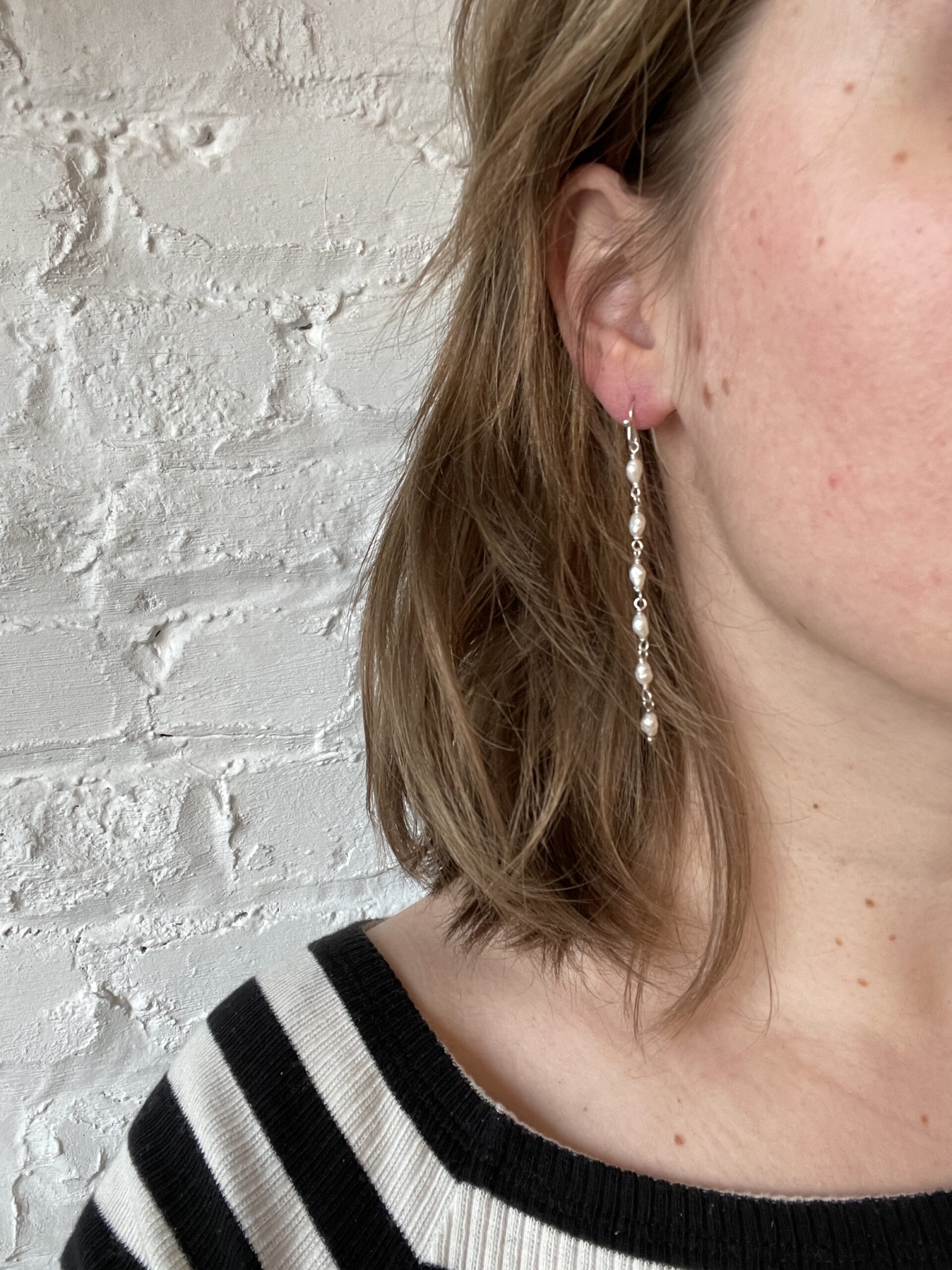 925 sterling zilveren oorring met natuurparel gedragen 925 sterling zilveren oorring met natuurparel aan oor